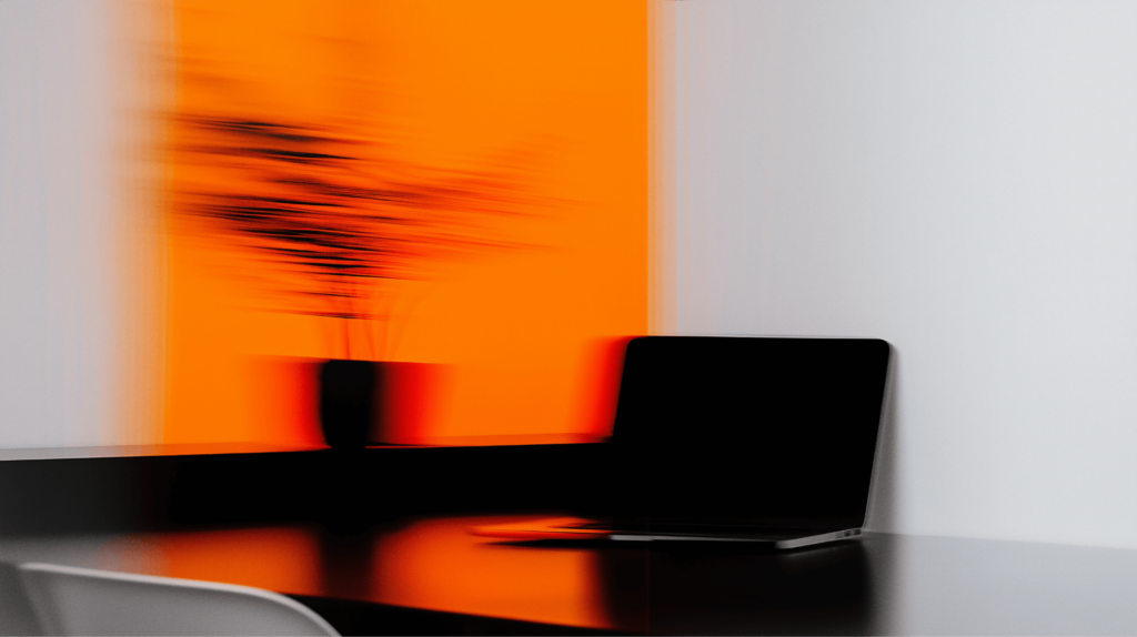 Foto von Arbeitsplatz mit Laptop mit orangem Motion-Blur Effekt.